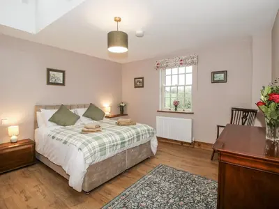 a bedroom with a bed and a desk and a window at Highfields Farm in Church Stretton