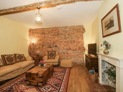 a living room with a brick wall at Highfields Farm in Church Stretton