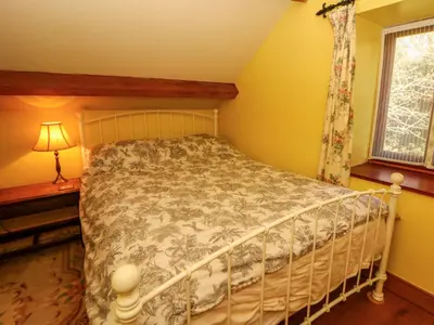 a bedroom with a bed in a room with a window at Maggie's Barn in Brecon