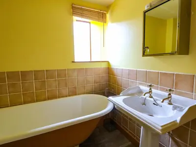 a bathroom with a tub and a sink and a bath tub at Maggie's Barn in Brecon