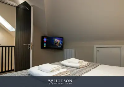 a bedroom with a bed with a flat screen tv on the wall at Modern 5 Bedroom Home in Shrewsbury in Shrewsbury