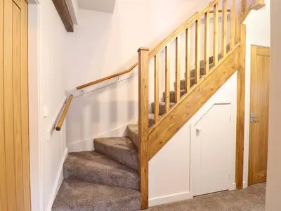 a staircase in a home with white walls at Clegir Bach in Corwen