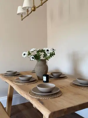 a wooden table with plates and a vase with flowers at Luxury Apartment in Shropshire sleeps 6 in Shrewsbury