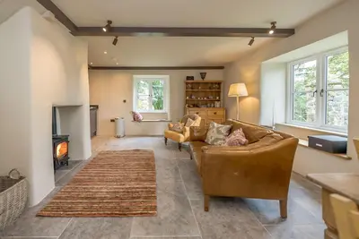 a living room with a couch and a fireplace at Deer-Park-Lodge in Llanfachreth