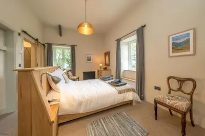 a bedroom with a bed and a chair at Deer-Park-Lodge in Llanfachreth