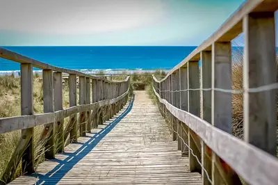 a wooden bridge over the ocean on the beach at Deer-Park-Lodge in Llanfachreth
