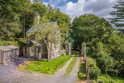 an old stone house in the middle of the forest at Deer-Park-Lodge in Llanfachreth