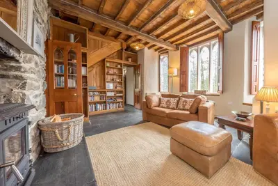 a living room with a couch and a fireplace at Hywel-Sele-Lodge in Llanfachreth