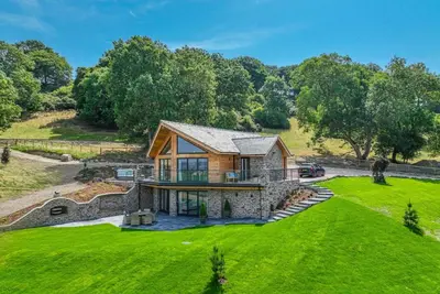 an estate with a stone house on a green lawn at Llety-Cariad in Montgomery