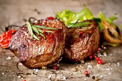 a piece of meat with vegetables on a table at Llety-Cariad in Montgomery