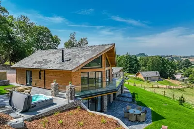 a log home with a swimming pool and a house at Llety-Cariad in Montgomery