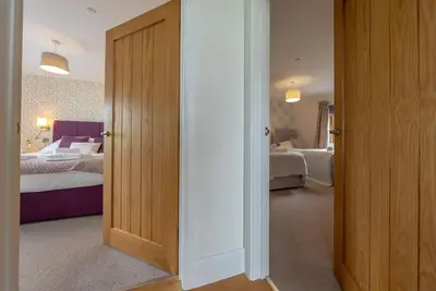 an open door to a bedroom with two beds at Llety-Hiraeth in Montgomery