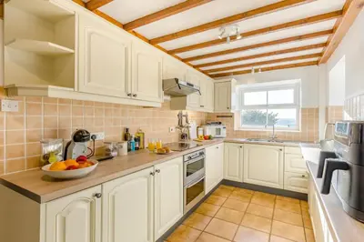 a kitchen with white cabinets and a wooden ceiling at 3 Bed in Rhydyfelin oc-c34178 in Rhyd-y-felin