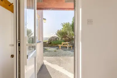 an open door to a patio with a table outside at 3 Bed in Rhydyfelin oc-c34178 in Rhyd-y-felin
