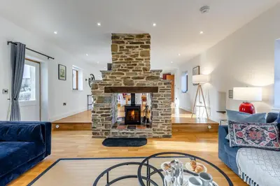 a living room with a stone fireplace and a blue couch at 3 Bed in Rhydyfelin oc-y34179 in Rhyd-y-felin