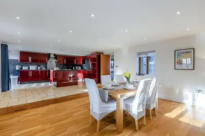 a kitchen and dining room with a wooden table and white chairs at 3 Bed in Rhydyfelin oc-y34179 in Rhyd-y-felin