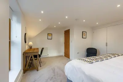 a bedroom with a bed and a desk with a chair at 3 Bed in Rhydyfelin oc-y34179 in Rhyd-y-felin