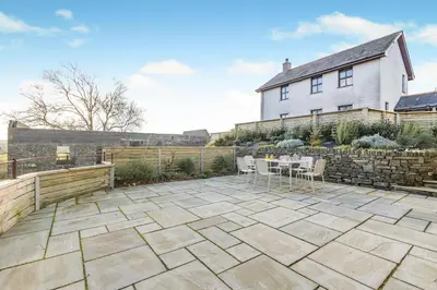 a patio with a table and chairs in front of a house at 3 Bed in Rhydyfelin oc-y34179 in Rhyd-y-felin