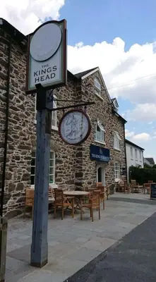 a sign in front of a building with tables and benches at The Kings Head, Meifod in Meifod