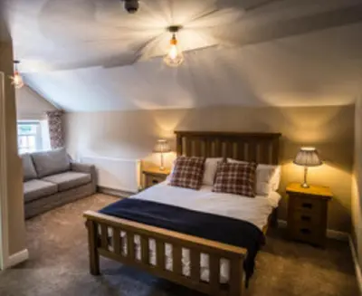 a bedroom with a large bed and a couch at The Kings Head, Meifod in Meifod