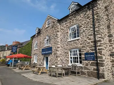 a stone building with tables and chairs in front of it at The Kings Head, Meifod in Meifod