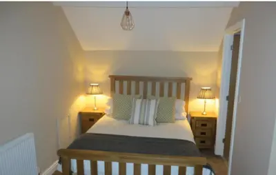 a bedroom with a bed with two lamps on both sides at The Kings Head, Meifod in Meifod
