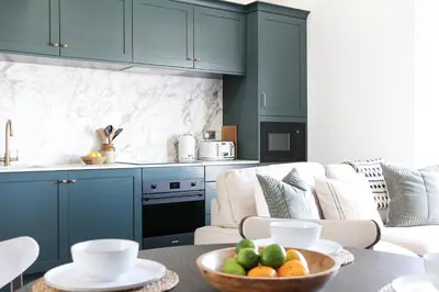 a kitchen with blue cabinets and a bowl of fruit on a table at Luxury Apartment in Shropshire sleeps 4 in Shrewsbury