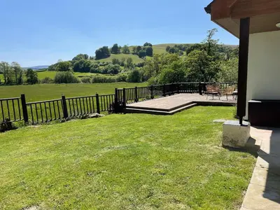 a house with a fence and a grass yard at Swn yr Coed in Sennybridge