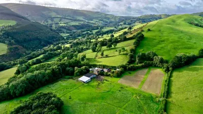 an aerial view of a farm in a green field at Y Beudy