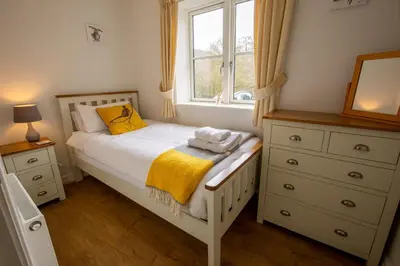a small bedroom with a bed and a window at Y Beudy