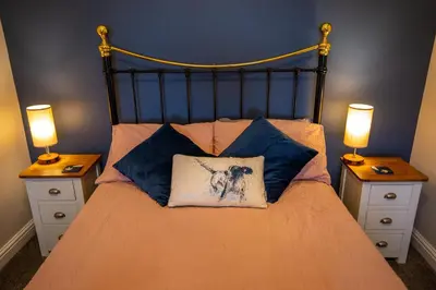 a bedroom with a bed with two night stands and two lamps at Penrhyllan