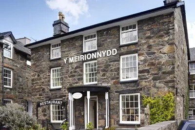 an old stone building with a sign on it at Y Meirionnydd Boutique Hotel in Dolgellau