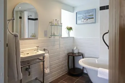 a bathroom with a tub and a sink and a bath tub at Y Meirionnydd Boutique Hotel in Dolgellau