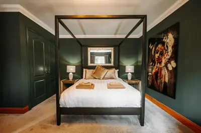 a bedroom with a canopy bed with two lamps at Cherry Tree House in Shrewsbury