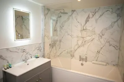 a bathroom with a sink and a shower and a tub at Bay View New Quay in New Quay