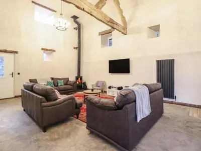 a living room with two couches and a tv at Godre'r Gyrn, Plas Moelfre Hall Barns in Oswestry