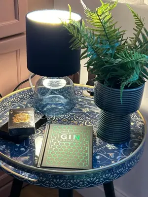 a table with a candle and a book on it at The Cwtch in Ludlow