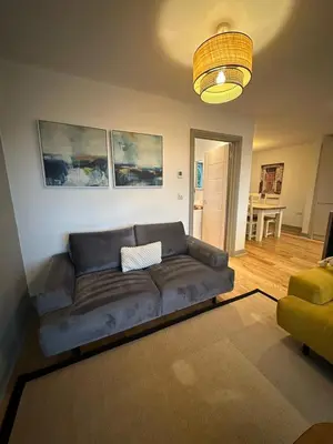 a living room with a leather couch in a living room at Woodland View House in Norton Canon