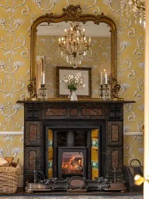 a fireplace in a living room with a mirror at Belmont House in Hay-on-Wye