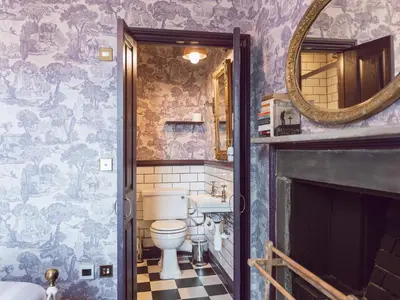 a bathroom with a toilet and a sink and a mirror at Belmont House in Hay-on-Wye
