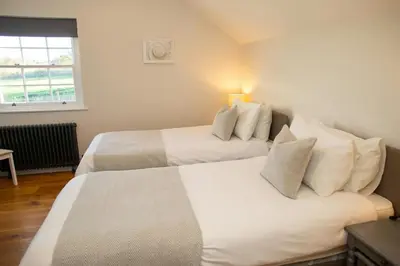 a bedroom with two beds and a window at Gelli Genlas Aberaeron in Llanarth