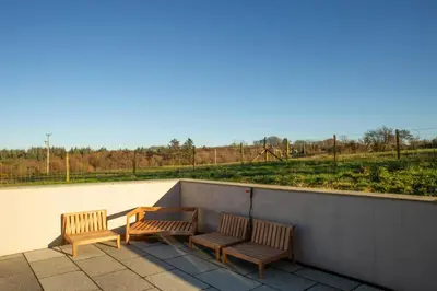three wooden benches sitting on top of a roof at Gelli Genlas Aberaeron in Llanarth
