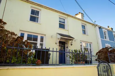 a white house with a gate and fence at 5 Rock Street New Quay in New Quay