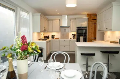 a kitchen with a table with flowers on it at 5 Rock Street New Quay in New Quay