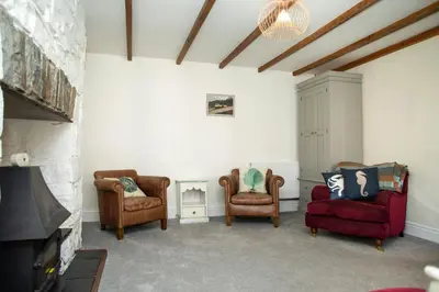 a living room with two chairs and a fireplace at 5 Rock Street New Quay in New Quay