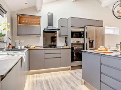 a kitchen with stainless steel appliances and wood floors at 3 Bed in Brecon oc-92341 in Brecon
