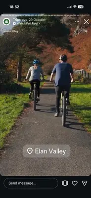 two people riding bikes down a road at Nant Hafren Retreat in Llanwnog