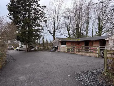 a barn with a car parked in a parking lot at Nant Hafren Retreat in Llanwnog