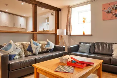 a living room with a leather couch and a table at Finest Retreats - Brecon House in Builth Wells