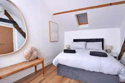 a bedroom with a large bed and a mirror at Finest Retreats - Brecon House in Builth Wells